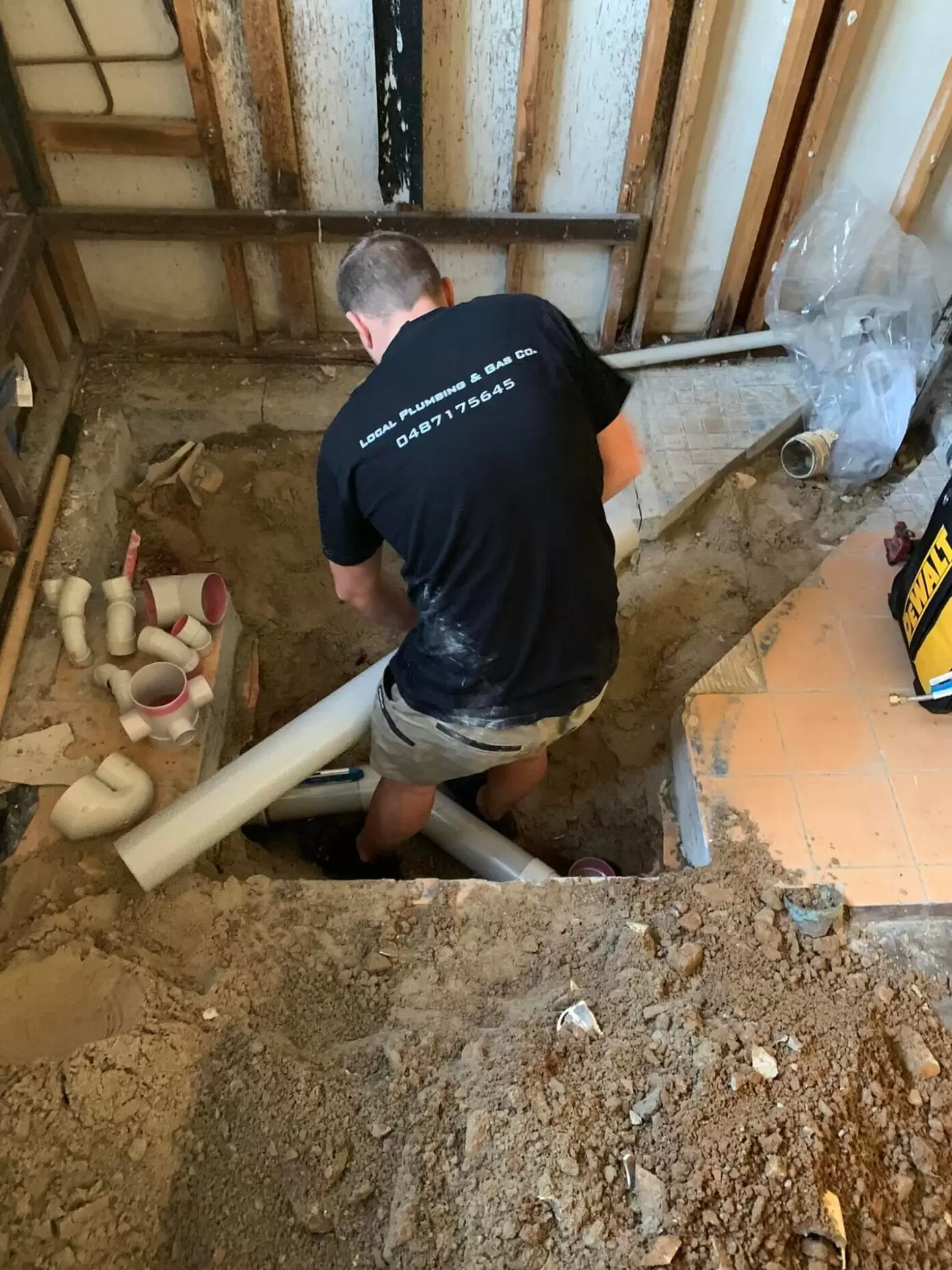 Plumber laying pipework during a bathroom renovation